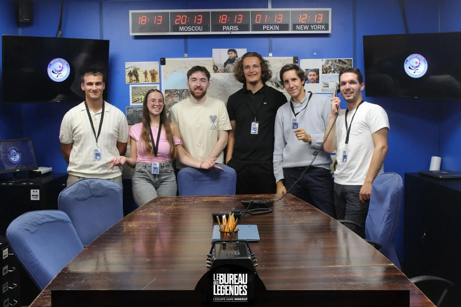 L'équipe réunie autour d'une table dans un escape game, badges au cou